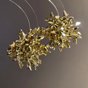 Macro dei raffinati orecchini a lobo a forma di fiore dorato con perline sfaccettate.