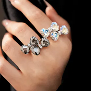 Close-up detail of rhinestone butterfly bow open rings featuring clear and grey stones