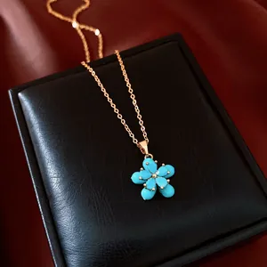 Detailansicht einer 18 Karat vergoldeten Blumenkette mit türkisfarbenen Blütenblättern