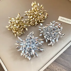 Dettaglio macro di eleganti orecchini a lobo floreali in cristallo sfaccettato oro e argento
