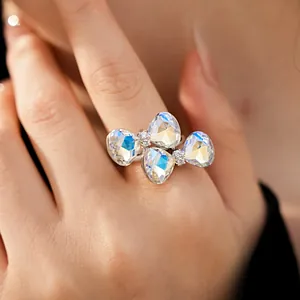 Detail of a silver-toned open ring with a butterfly bow made of iridescent crystals.