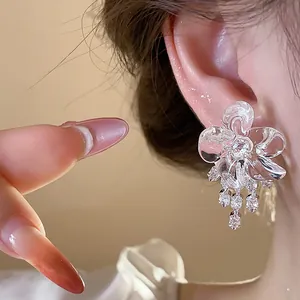 Close-up detail of elegant transparent resin flower earrings featuring sparkling zircon tassels