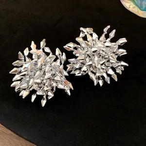 Vista dettagliata di orecchini a lobo a fiore argento sfaccettato stile vintage.