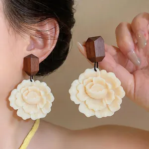 Macro detail shot showing the textures of wood and resin flower statement earrings