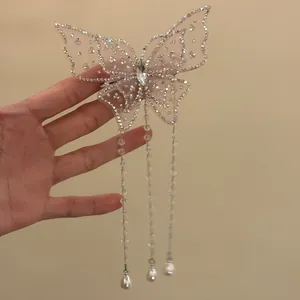 Detailed view of a sparkly butterfly hair clip with elegant long pearl tassels.