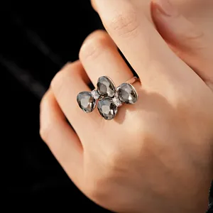 Detail shot of elegant butterfly ring featuring grey pear-shaped crystals on a finger