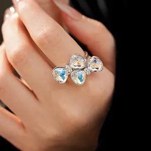 Close-up detail of silver butterfly ring with four heart-shaped iridescent crystals and pave stones