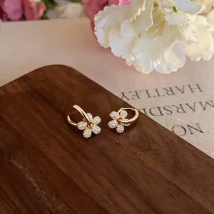 Dettaglio degli orecchini a cerchio con pendente a fiore in zircone placcato oro 14 carati