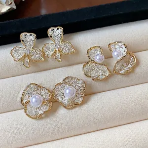 Elegant 18K gold-plated floral stud earrings with white pearls and intricate lace detail
