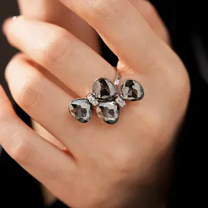 Macro detail view of an elegant silver butterfly ring with dark gray faceted gemstones