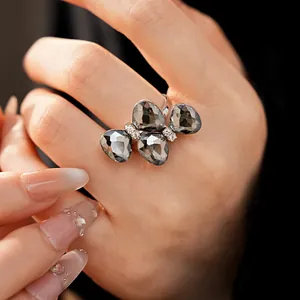 Macro detail view of a silver butterfly ring with smoky grey crystals and micro rhinestones