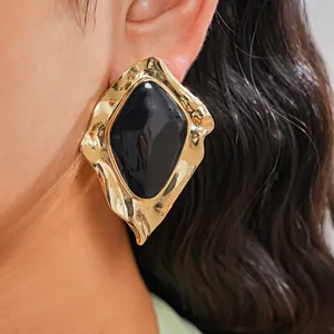 Detailansicht eines Vintage-Ohrsteckers in unregelmäßiger geometrischer Form mit schwarzer Emaille