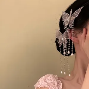 Close-up of sparkling butterfly hair clips with pearl tassels on a woman's hair