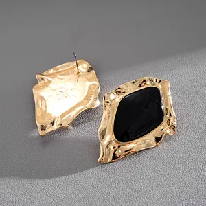 Detailansicht unregelmäßiger goldgerahmter Emaille-Ohrstecker in Schwarz im Vintage-Stil