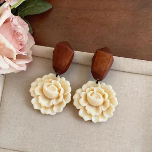 Detailed close-up showing the texture of elegant wood and resin flower drop earrings