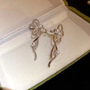 Dettaglio di orecchini a clip in argento con zirconi scintillanti e perle eleganti