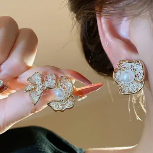 Detail shot of vintage lace flower pearl earrings with 18K gold plating.