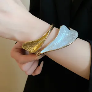Close-up of elegant retro wrinkled flower open bracelet in gold and white finish.