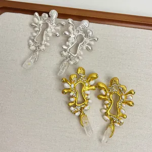 Dettaglio di orecchini retrò a forma di serratura con placcatura oro, perle e strass