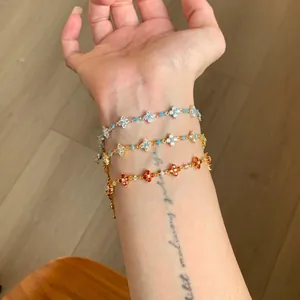 Detailed view of three clover bracelets in gold and silver with colorful zircons