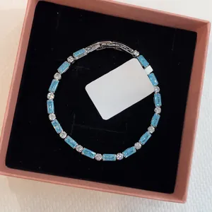 Detail view of light luxury bracelet with blue rectangular zircons in a box