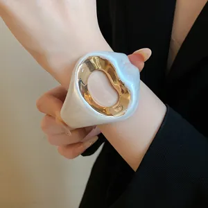 Detailed view of an elegant vintage-style crinkled pearlescent and gold open bangle.