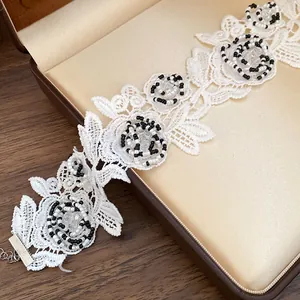 Close-up of elegant white lace choker necklace with intricate black and white beaded flowers