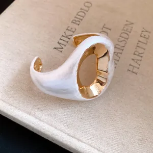 Detailed macro view of an elegant white and gold crinkled vintage style open bangle