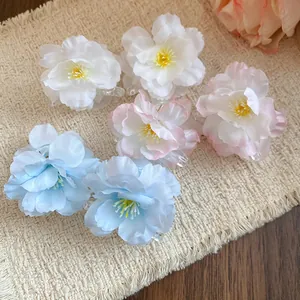 Close-up of elegant fabric flower duckbill hair clips in white, pink, and light blue colors