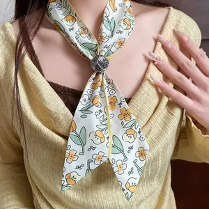 Detailed view of floral printed fabric neck scarf with a decorative round buckle on model