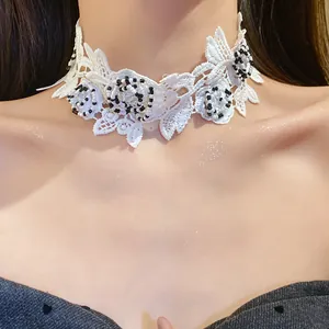 Detailed view of white lace choker necklace with black and clear beaded flowers