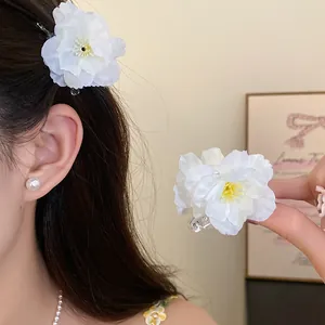Close-up of elegant white fabric flower hair clip showing delicate petal textures