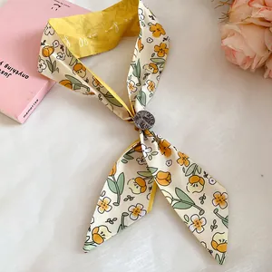 Close-up of floral print fabric scarf necklace with unique wooden button detail.