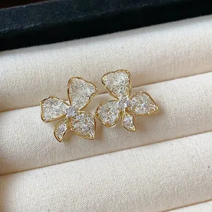 Close-up of elegant 18K gold plated lace flower stud earrings with crystal center