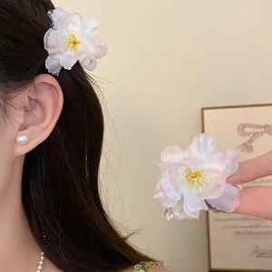 Detailed view of peach pink flower hair clip on model showing the delicate fabric petals