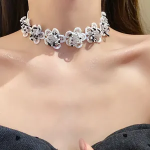 Close-up of white lace flower choker with black and white glass beads on model.