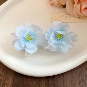 Close-up of elegant light blue fabric flower hair clips with delicate petals