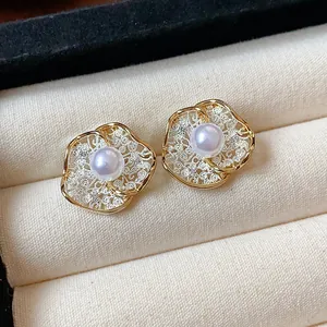 Exquisite detail of 18K gold plated flower stud earrings featuring elegant white pearls.