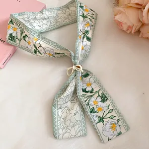 Close-up of an elegant floral print silk scarf with a decorative wooden flower buckle