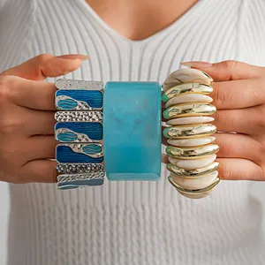 Vista dettagliata di un bracciale in resina blu marmorizzata e bracciali elastici dorati