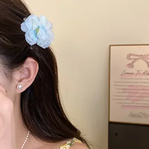 Close-up detail view of an elegant light blue fabric flower hair clip worn by a model