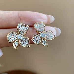 Close-up of exquisite hollowed lace flower earrings with sparkling pavé stones