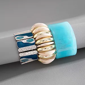 Dettaglio di bracciali elastici in smalto e resina con un bracciale in acrilico blu