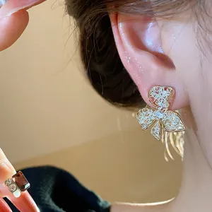 Detailed close-up of a gold-plated flower stud earring with intricate filigree design