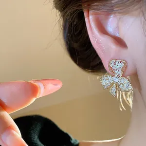 Close-up detail of 18K gold plated flower stud earrings with filigree and crystals