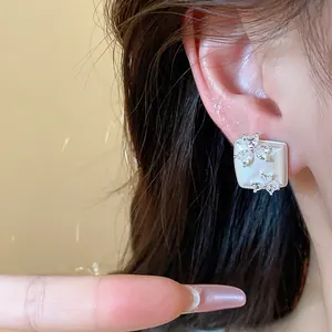 Close-up view showing the intricate detail of silver-toned geometric square earring