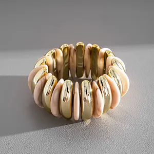 Dettaglio macro di bracciale elastico geometrico con segmenti dorati e resina marmorizzata
