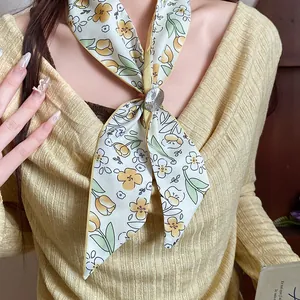 Close-up view of an elegant floral printed fabric scarf with decorative flower slide