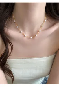 Close-up of a delicate French-style pearl beaded necklace on a female model's collarbone