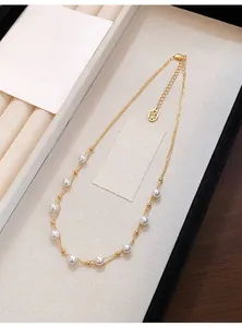 Detail shot of elegant French style gold-plated necklace with white pearls on box